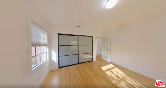 a view of empty room with wooden floor and cabinet