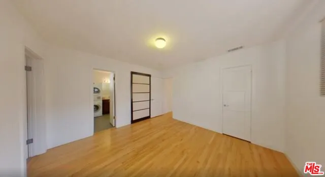 a view of empty room with wooden floor