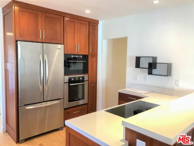 a kitchen with stainless steel appliances a refrigerator and a stove top oven