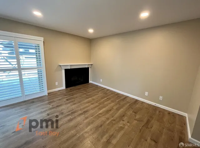 an empty room with wooden floor and fireplace