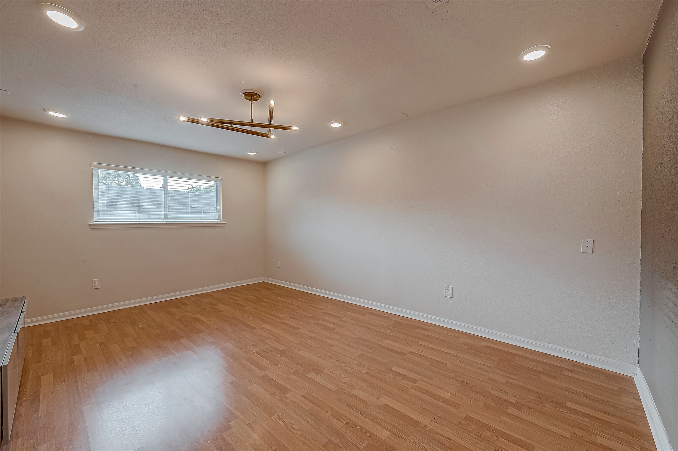 7497 Brompton Street, Unit 7497 Houston, TX 77025 - Photo 23 of 27 an empty room with wooden floor ceiling fan and windows