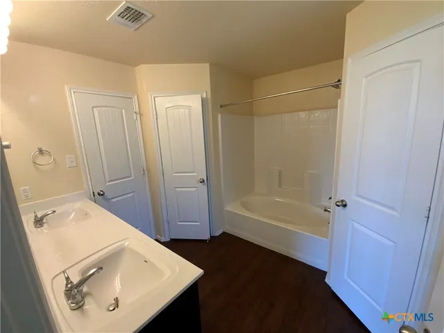 a bathroom with a tub sink and mirror