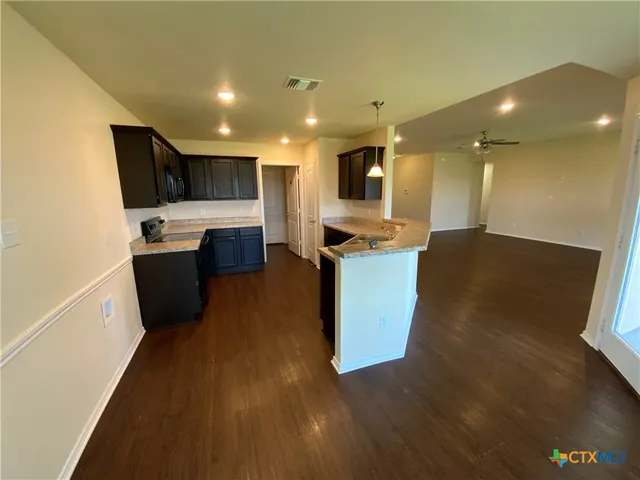 a view of a kitchen with cabinets and wooden floor