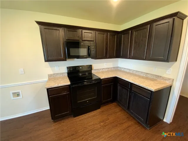 a kitchen with wooden cabinets and black appliances