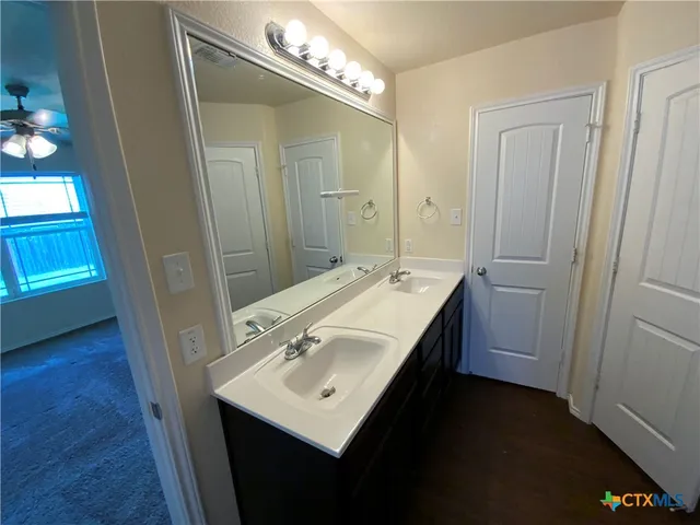a bathroom with a sink a light fixture a vanity and a mirror