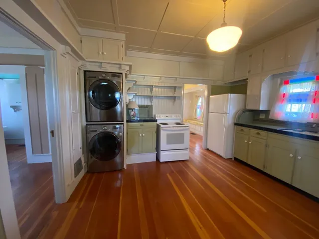 a kitchen with stainless steel appliances wooden floor and a refrigerator