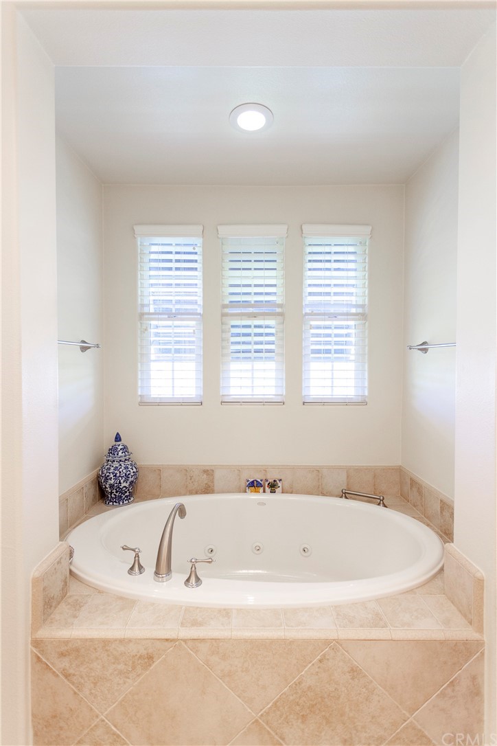 21246 Baeza Circle Huntington Beach, CA 92648 - Photo 27 of 49 a white bath tub sitting in a spacious bathroom next to a window