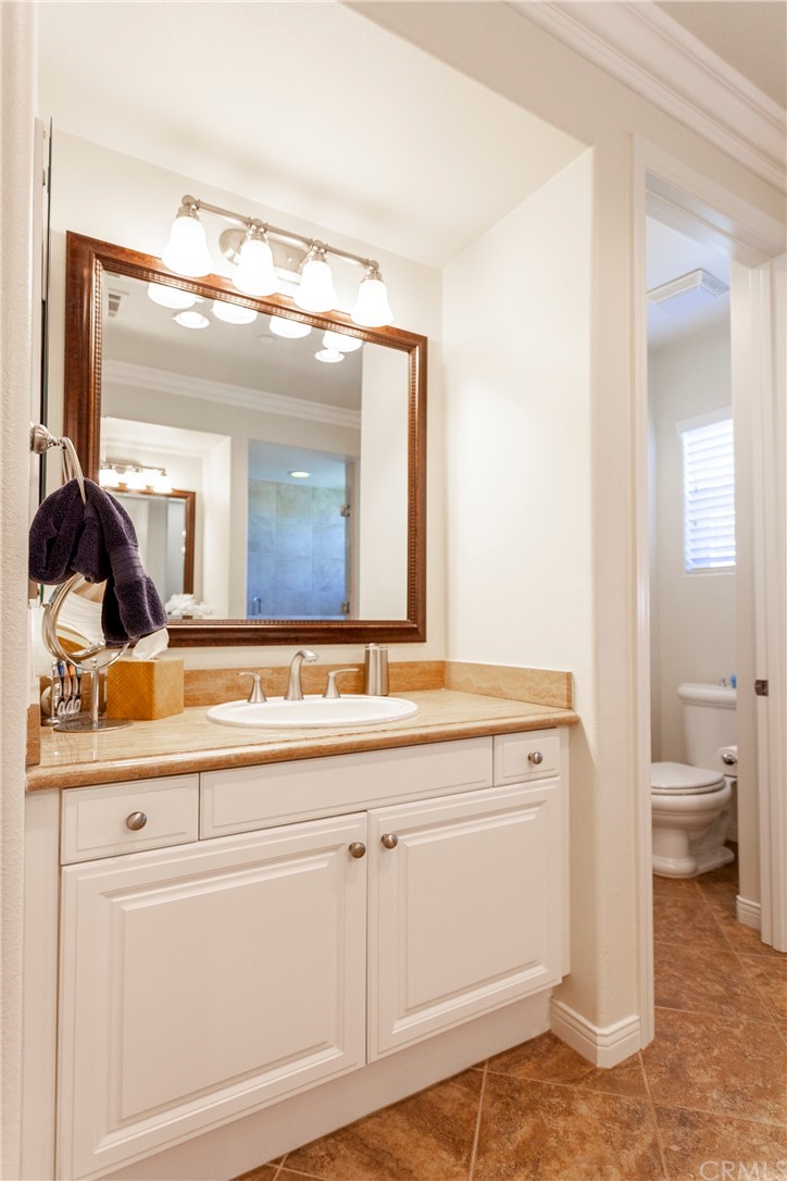 21246 Baeza Circle Huntington Beach, CA 92648 - Photo 28 of 49 a bathroom with a double vanity sink and a mirror