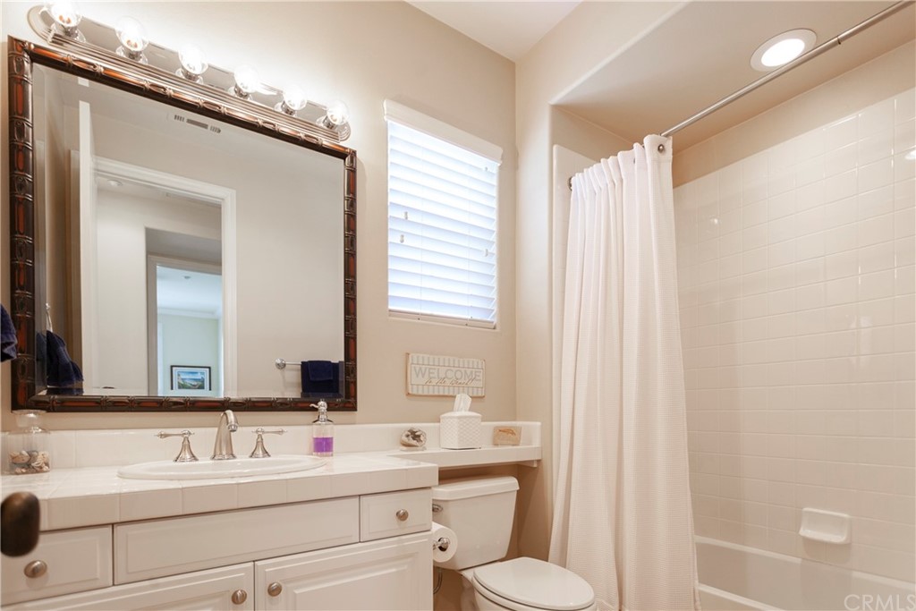 21246 Baeza Circle Huntington Beach, CA 92648 - Photo 32 of 49 a bathroom with a double vanity sink toilet and a mirror