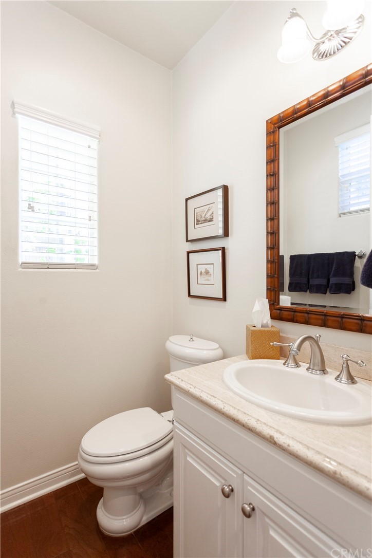 21246 Baeza Circle Huntington Beach, CA 92648 - Photo 8 of 49 a bathroom with a granite countertop toilet sink and mirror