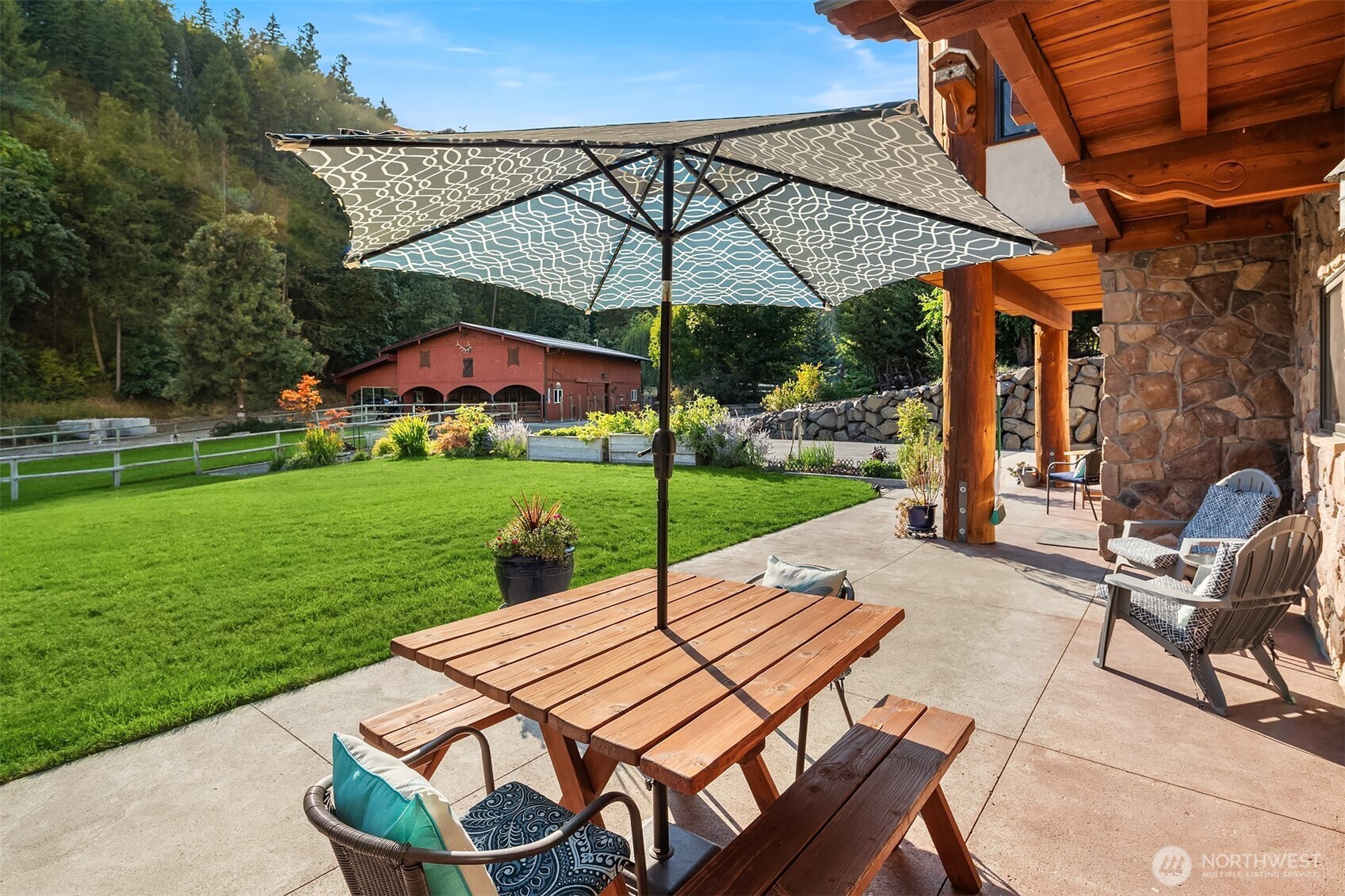 951 Willems Road Cashmere, WA 98815 - Photo 32 of 40 a patio with a table and chairs under an umbrella