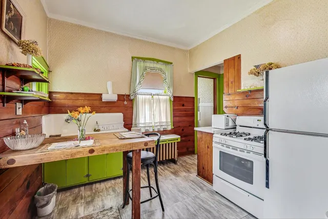 a kitchen with a table chairs refrigerator and cabinets