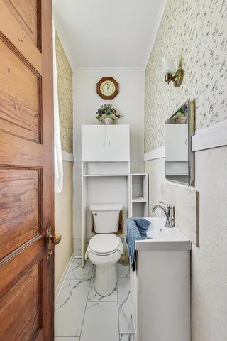 a bathroom with a toilet sink and mirror