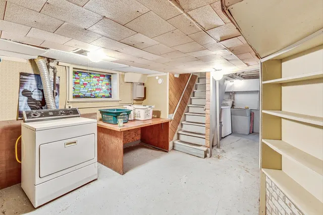 a view of a hallway with stairs and furniture