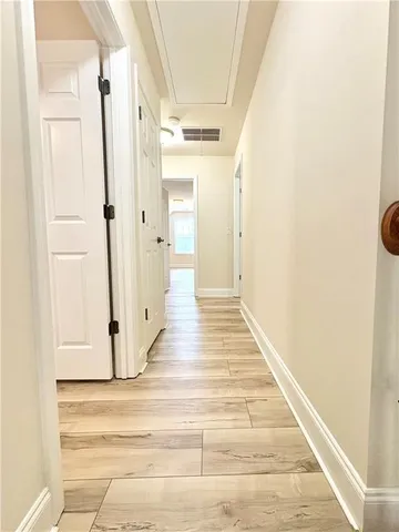 a view of a hallway with wooden floor and staircase