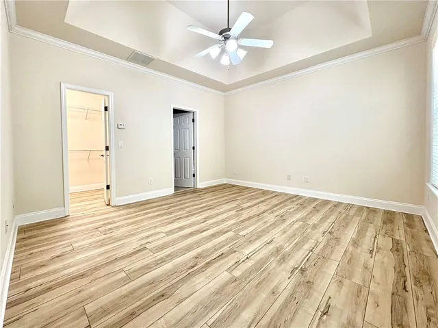 a view of a room with wooden floor and a ceiling fan
