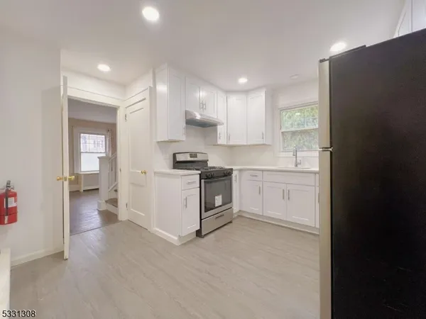 a kitchen with white cabinets and white appliances