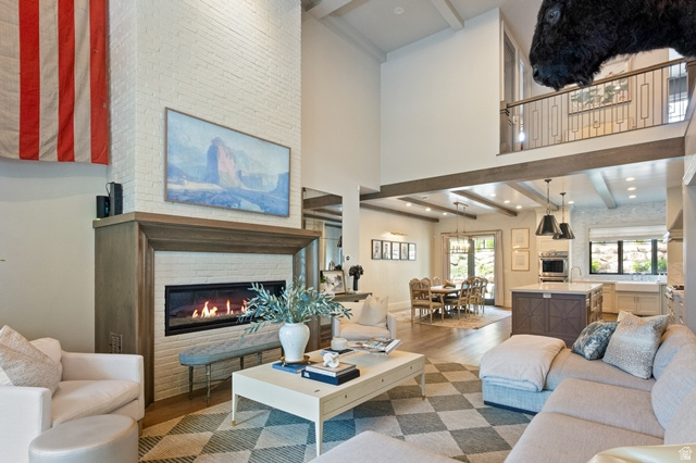 3 Carriagewood Cove, Unit 1088 Sandy, UT 84092 - Photo 17 of 79 Spacious living area featuring a tall brick fireplace with a wood mantle, high ceilings, and exposed beam accents