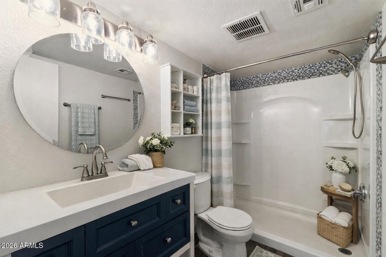 30 East Brown Road, Unit 2070 Mesa, AZ 85201 - Photo 13 of 20 a bathroom with a granite countertop sink a toilet a glass door shower and a mirror