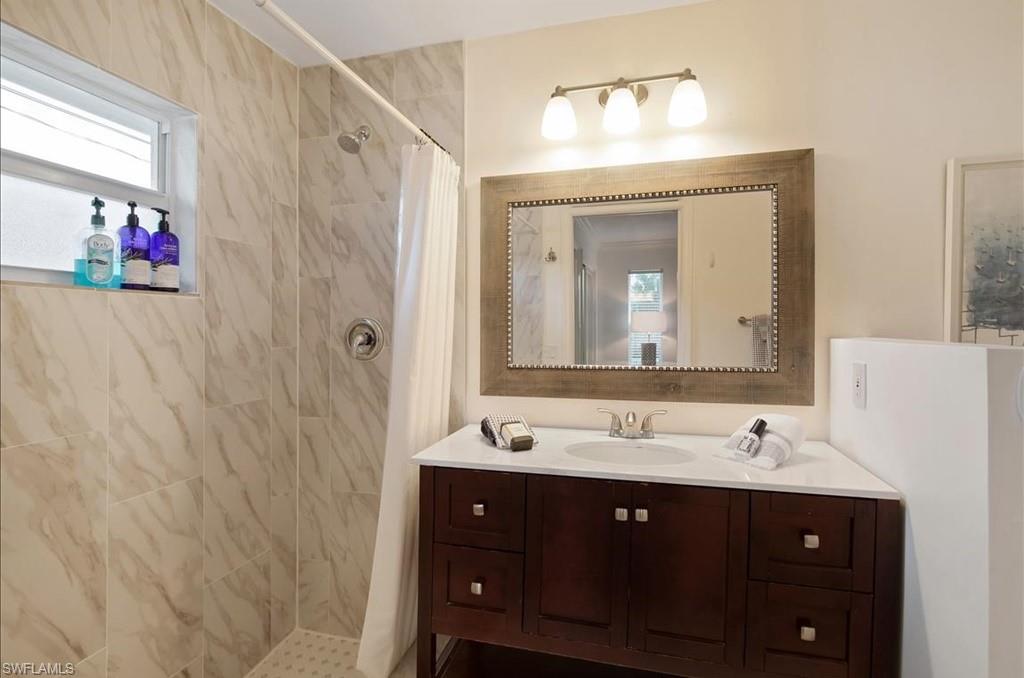 552 105th Avenue North Naples, FL 34108 - Photo 9 of 17 a bathroom with a sink vanity and a mirror