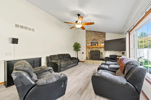 a living room with furniture ceiling fan and a window