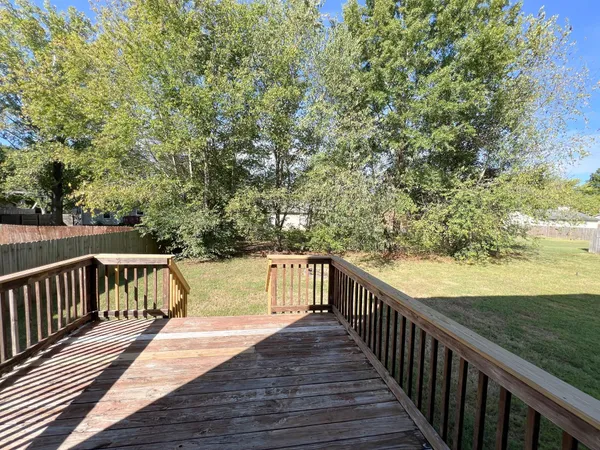 a view of balcony with wooden floor and fence
