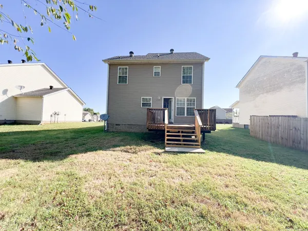 a view of backyard with wooden fence and seating