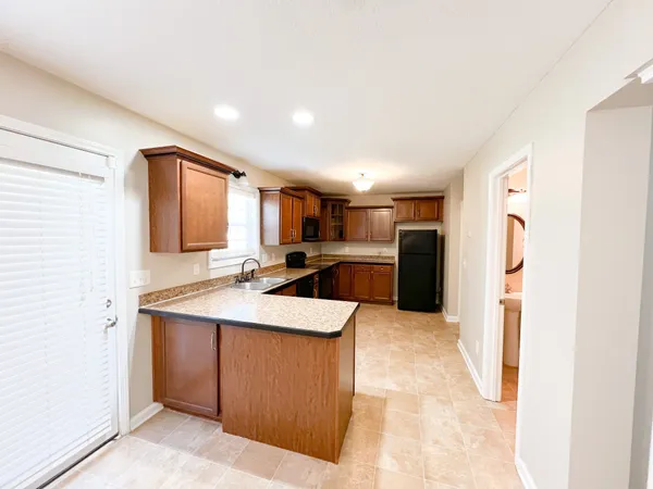 a kitchen with stainless steel appliances granite countertop a sink and a refrigerator