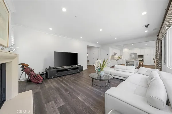 a kitchen with stainless steel appliances kitchen island granite countertop a stove top oven a sink dishwasher a dining table and chairs with wooden floor