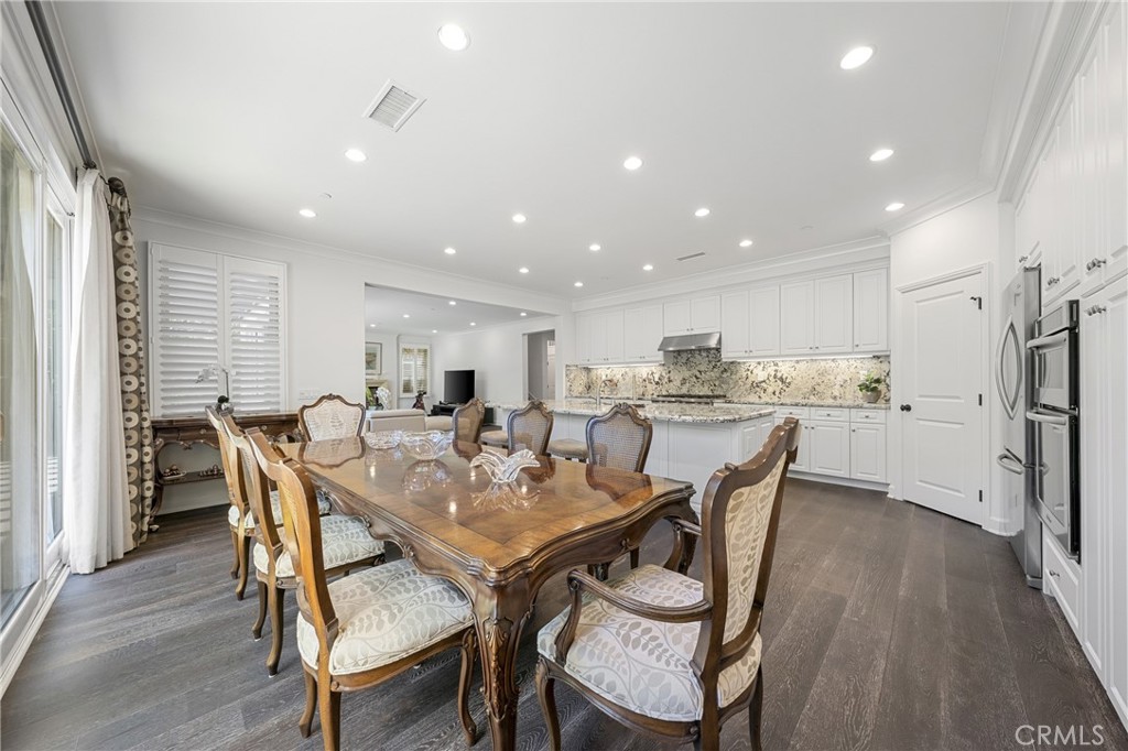 45 Triana Irvine, CA 92618 - Photo 16 of 39 a view of a dining room and livingroom with furniture wooden floor a rug a kitchen view and a chandelier