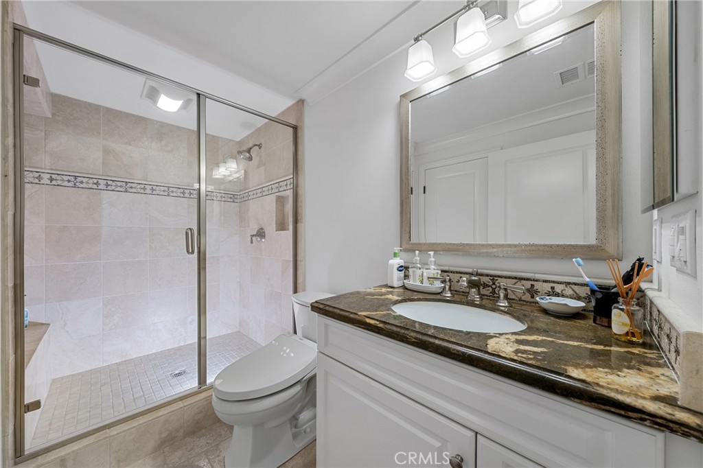 45 Triana Irvine, CA 92618 - Photo 18 of 39 a bathroom with a granite countertop sink a toilet a mirror and shower