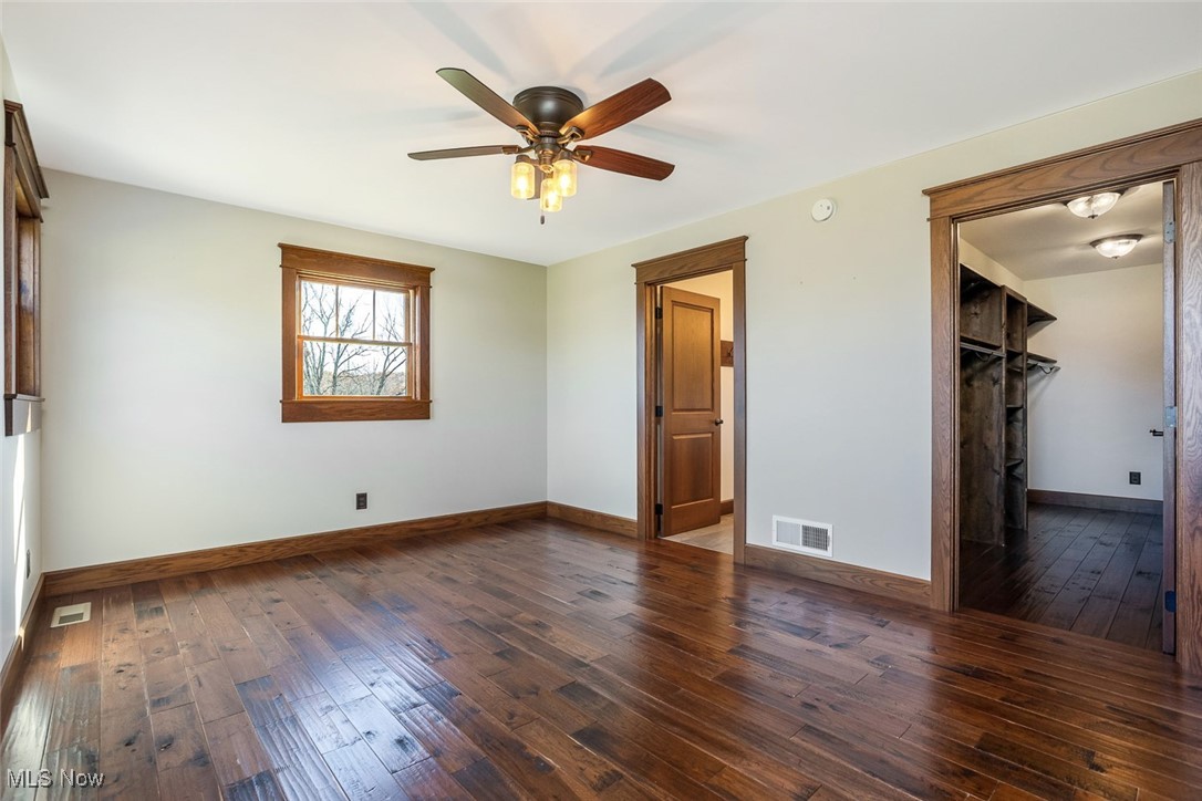 9615 Rural Dale Road Blue Rock, OH 43720 - Photo 21 of 50 Unfurnished bedroom with dark wood finished floors, a walk in closet, and a ceiling fan