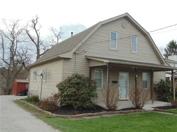 a view of a white house with a yard and plants
