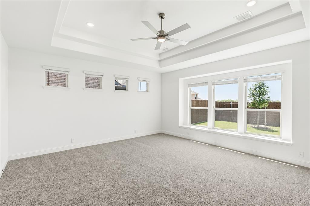 1145 Hitching Post Way Oak Point, TX 75068 - Photo 24 of 39 an empty room with a ceiling fan and windows