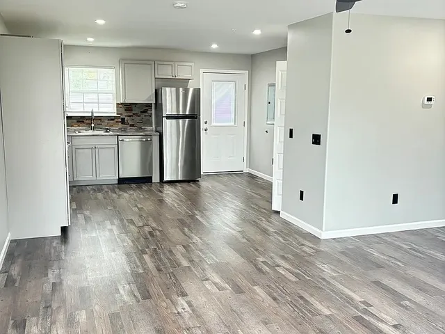 a kitchen with wooden floors and refrigerator