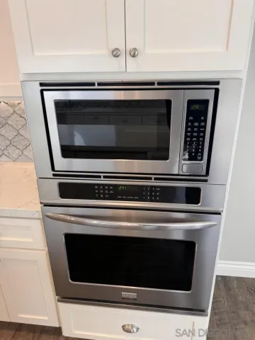 a view of empty room with wooden floor and fireplace