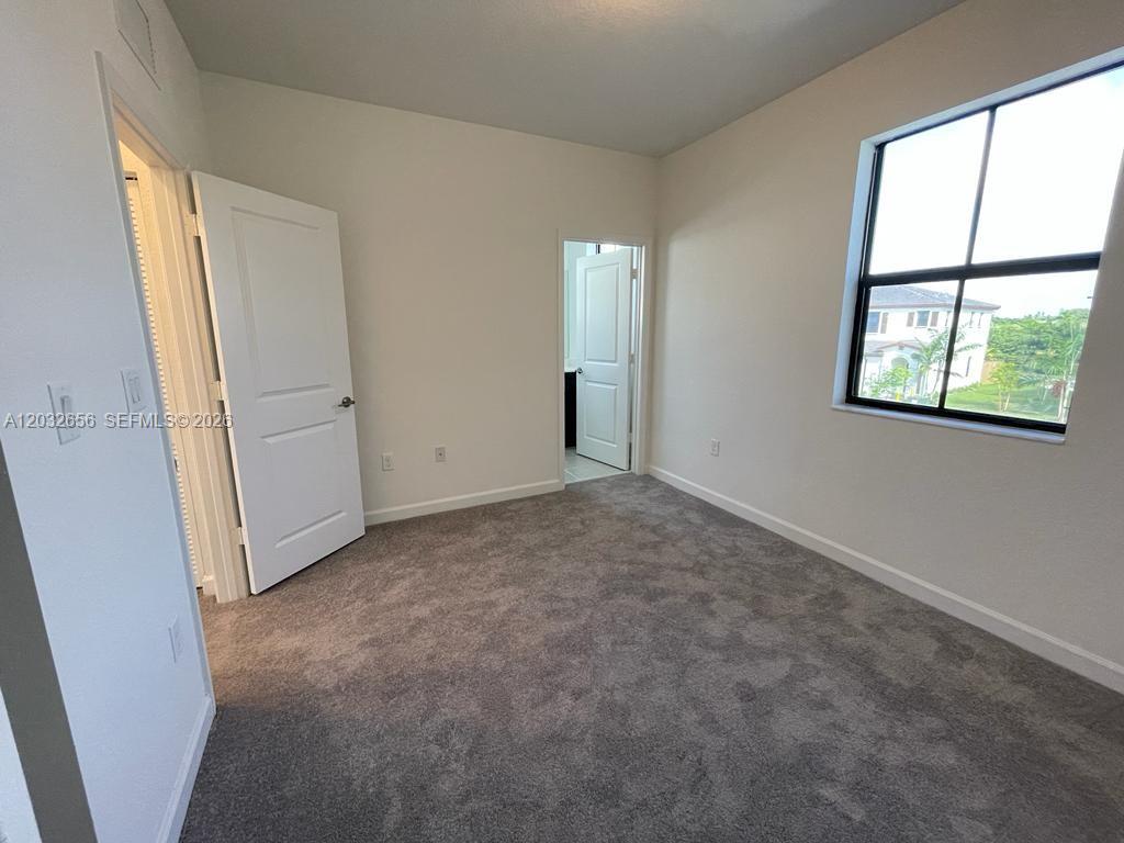 10144 Southwest 228th Terrace Miami, FL 33190 - Photo 11 of 23 an empty room with windows and closet