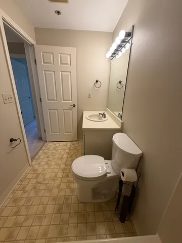 a bathroom with a toilet sink and mirror