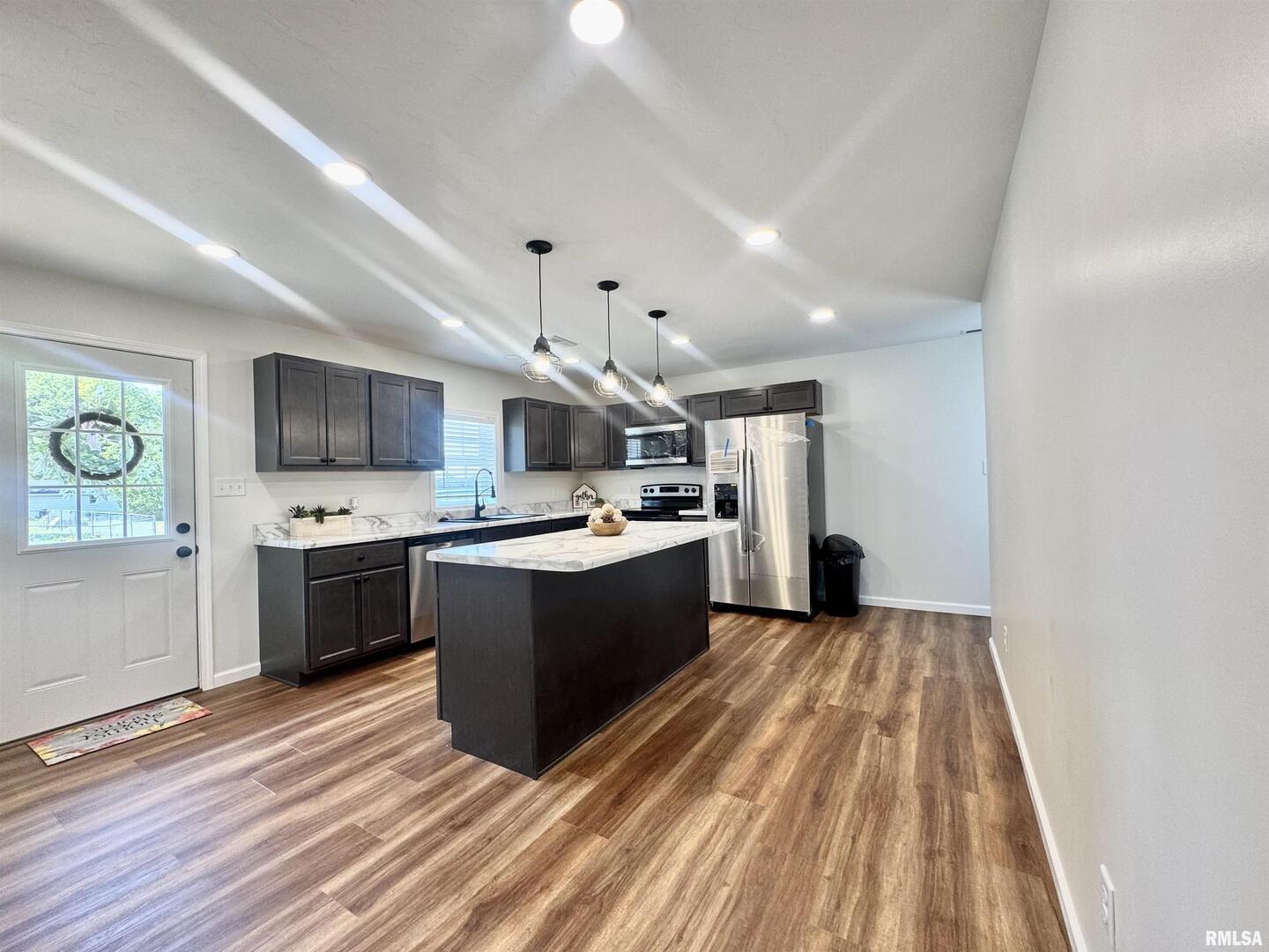 309 West Main Street Ewing, IL 62836 - Photo 13 of 37 a large kitchen with a large counter top a sink stainless steel appliances and cabinets