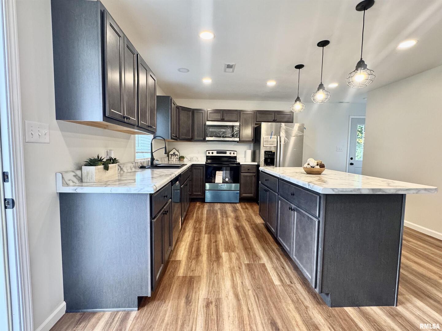 309 West Main Street Ewing, IL 62836 - Photo 15 of 37 a large kitchen with stainless steel appliances kitchen island granite countertop a sink dishwasher stove and cabinets with wooden floor