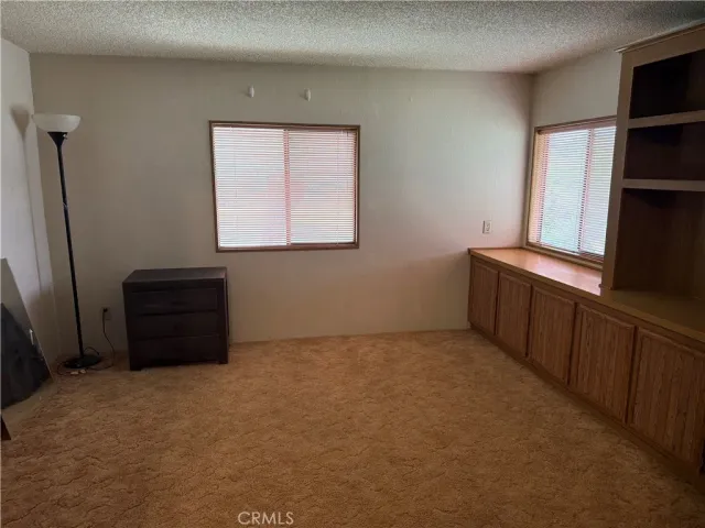 a room with a window and a dresser