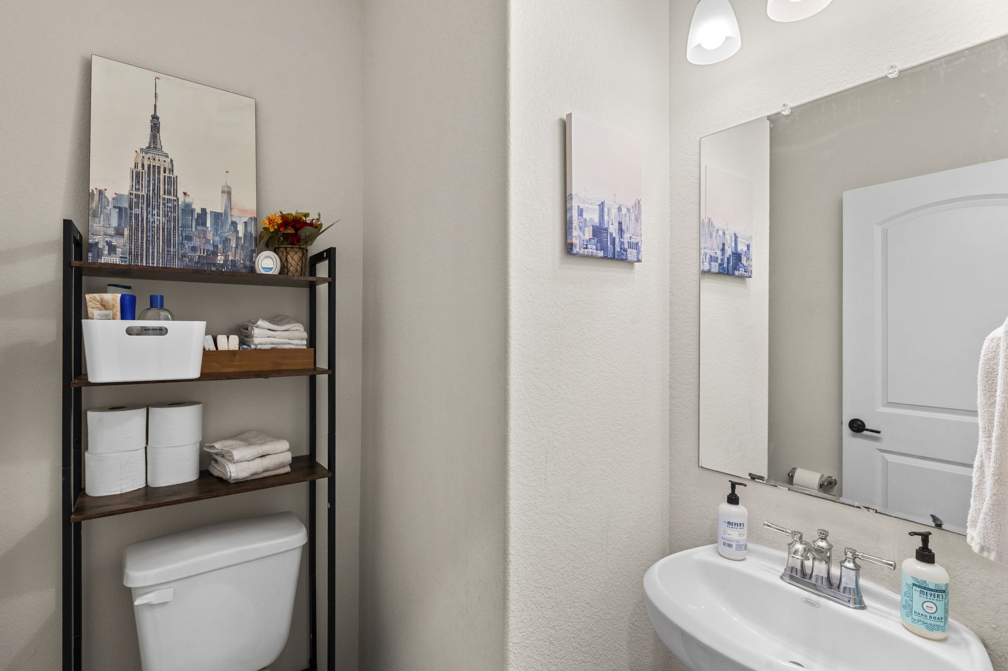 548 Purple Heart Drive Buda, TX 78610 - Photo 13 of 35 A compact and functional bathroom space, featuring a pedestal sink and convenient shelving for storage.