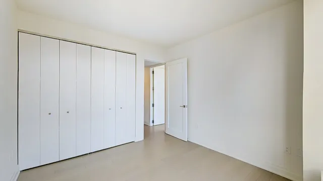 a room with a large window and a white bed