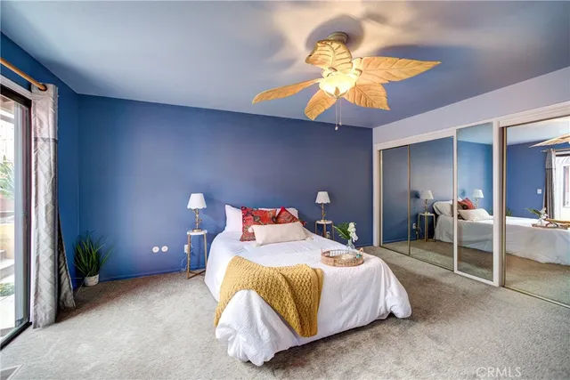 a view of a livingroom with a fireplace a ceiling fan and wooden floor