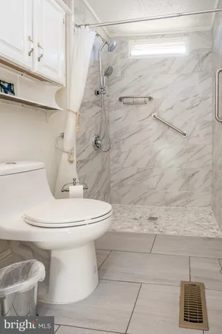 a white toilet sitting next to a bathroom
