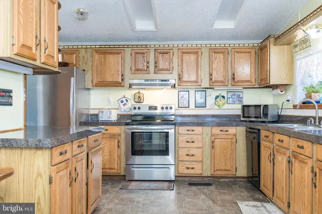 a kitchen with stainless steel appliances granite countertop a sink stove and cabinets