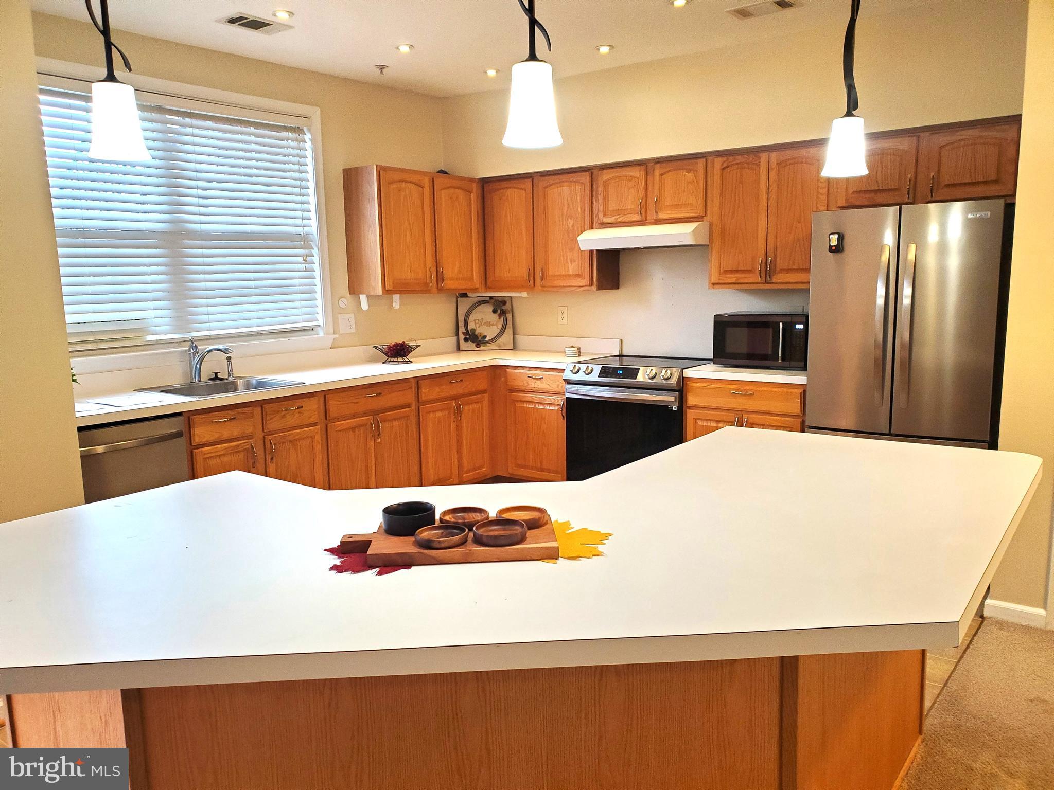 2433 Wentworth Drive Crofton, MD 21114 - Photo 4 of 18 a large kitchen with stainless steel appliances granite countertop a refrigerator a sink dishwasher a stove and white countertops with cabinets