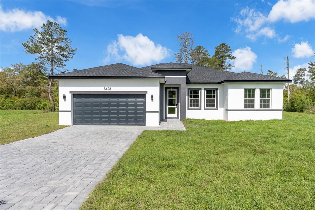 3428 Southwest 165th Loop Ocala, FL 34473 - Photo 1 of 43 a front view of a house with a garden and yard