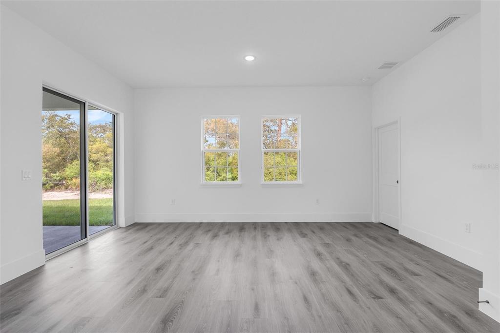 3428 Southwest 165th Loop Ocala, FL 34473 - Photo 17 of 43 an empty room with wooden floor and windows
