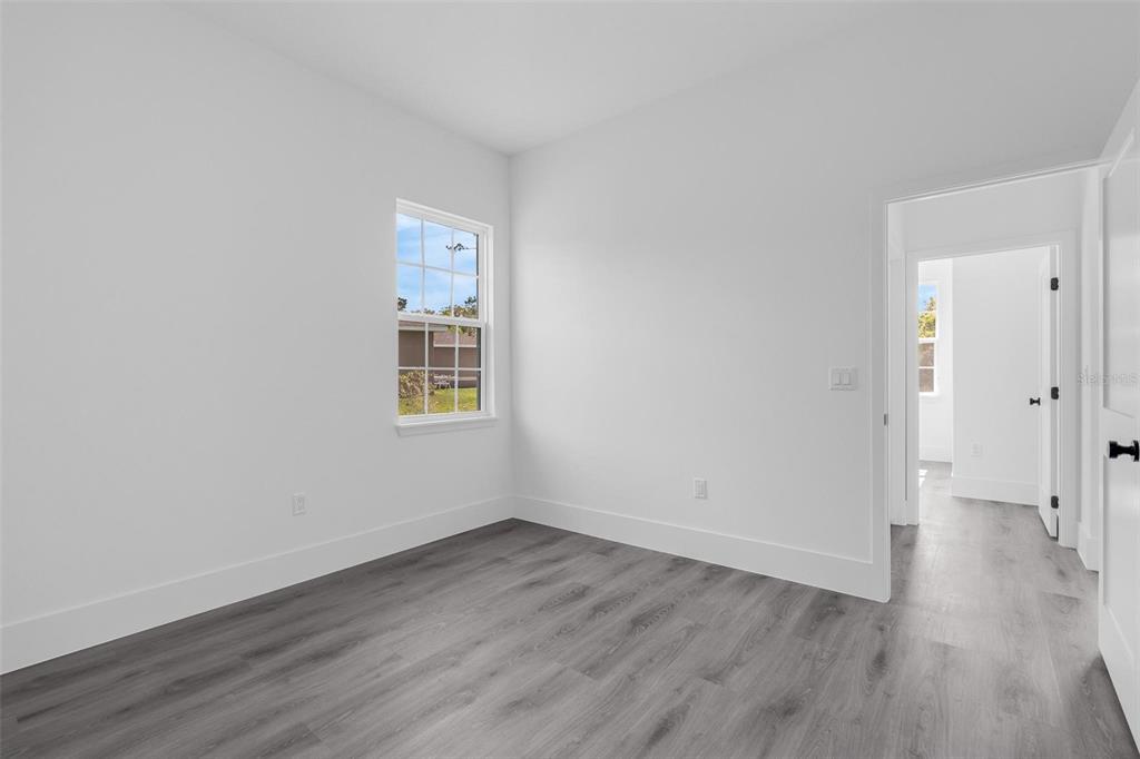3428 Southwest 165th Loop Ocala, FL 34473 - Photo 19 of 43 a view of an empty room with wooden floor and a window